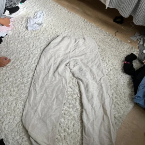 Beiga linnebyxor med resårmidja - Säljer ett par beiga linnebyxor med resår i midjan och avslappnad passform. Byxorna har raka ben och är tillverkade i ett lätt och luftigt linnematerial, perfekta för varmare dagar. Enkla att matcha och riktigt sköna att bära.