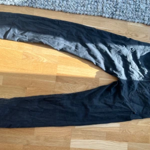 Svarta slim fit jeans  - Svarta jeans från Dressmann i slim fit-modell. Klassisk femficksdesign och raka ben med smal passform. Jeansen är tillverkade i ett mjukt bomullsmaterial med lite stretch för extra komfort. Perfekta för dig som gillar en stilren och enkel look.