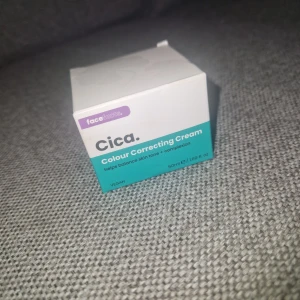 Ansiktskräm - Cica Colour Correcting Cream från Face Facts i en glasburk med silverlock, 50 ml. Krämen är ljusgrön och hjälper till att jämna ut hudtonen och dämpa rodnad. Innehåller grönt te, kamomill och cica-extrakt. Vegansk formula och lätt konsistens.