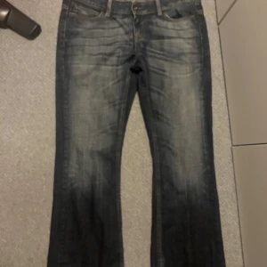 Blå bootcut jeans från ONLY, 42/32 - Snygga blå jeans från ONLY i modellen Auto Low Boot Cut. Jeansen har låg midja, klassisk femficksdesign och bootcut-ben. Materialet är jeans med lätt slitning framtill och bak. Perfekta för dig som gillar en avslappnad och trendig look.