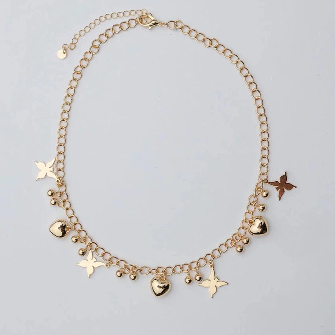 Guldigt halsband med hjärtan och stjärnor