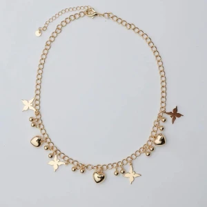 Guldigt halsband med hjärtan och stjärnor - Charmigt guldigt halsband med kedja och hängande detaljer i form av hjärtan, små bollar och stjärnliknande former. Perfekt accessoar för att lyfta din outfit med en lekfull och trendig touch. Från bow19 ny pris 399kr