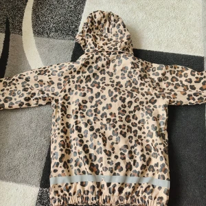 Leopardmönstrad regnjacka från Didriksons - Säljer en väldigt fin och äkta jacka från True North - Nordic design for Nordic weather. Materialet är vattentätt och perfekt för regn och rusk, med både dragkedja och knappar för extra skydd. Insidan är varm och bekväm. Tyg och kvalitet känns riktigt exklusivt.  Jackan är i nästan helt nytt skick och ser knappt använd ut. Passar perfekt, men tyvärr växt ifrån den.  En jacka som både är praktisk, snygg och hållbar. Skicka gärna om du har frågor!