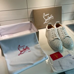 Vita Christian Louboutin skor med spikar - Riktigt snygga Christian Louboutins som jag säljer eftersom dom är för stora för mig. Skorna kommer i en snygg skolåda med lite tillbehör i som extra spikar samt en skopåse, Använda ca 5 gånger så lite smuts under men inget märkvärdigt. Bara att höra av sig om det är några funderingar.