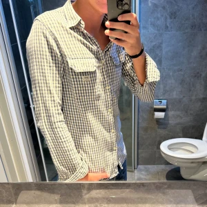 Rutig skjorta från Ralph Lauren - Snygg rutig skjorta från Denim & Supply Ralph Lauren i blått och vitt. Skjortan har klassisk krage, två bröstfickor med knappar och långa ärmar. Skjortan har inga defekter och är i bra skick. Jag är 188cm och bär storlek S och den sitter ganska tight på mig. Hör av er vid frågor ;)