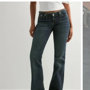 Blå bootcut jeans med låg midja - Snygga blå jeans med bootcut och låg midja. Jeansen har klassisk femficksdesign, synliga sömmar och dragkedja med knapp framtill. Perfekta för en avslappnad och trendig look.