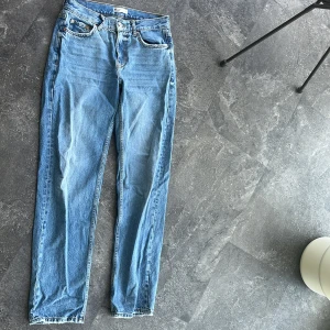 Blå jeans från Ginatrict, stl 34 - Snygga blå jeans från ginatricot i rak modell. Tillverkade av ekologisk bomull, klassisk femficksdesign och normal passform. Perfekta för dig som gillar en enkel och tidlös look. Färgen är ljusblå och materialet känns mjukt men slitstarkt.