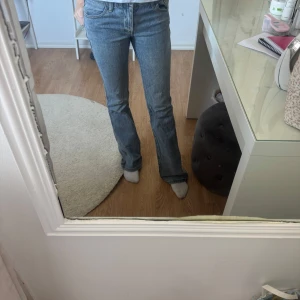 Bootcut jeans från Brandy Melville - Säljer ett par klassiska bootcut jeans från J.Galt i ljusblå denim. Byxorna har en rak passform upptill och utsvängda ben, tillverkade i 99% bomull och 1% elastan för lite stretch. Perfekta för dig som gillar en retro vibe och vill ha ett par snygga jeans med bekväm känsla.