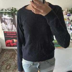 Mörkblå stickad tröja från Vila - En enkel och stilren mörkblå stickad tröja från Vila. Tröjan har rund halsringning, långa ärmar och ribbade muddar vid ärmslut och nederkant. Perfekt att slänga på sig när det är lite kyligare ute.