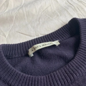 Mörkblå stickad tröja -  A Day's March - En klassisk mörkblå stickad tröja från A Day's March i 100% högkvalitativ merinoull. Tröjan har rund halsringning, ribbade muddar och är långärmad. Passformen är otroligt bra. Perfekt nu för vintern. Enda defekten är en i stort sett osynlig lagning på insidan av högerarmen, men utöver det är tröjan i mycket gott skick utan noppror eller liknande. Hör gärna av er vid frågor!