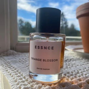 ESSNCE Parfym - Orange Blossom  - Orange blossom från ESSNCE. ”Denna doft öppnar med en friskhet av bergamott, neroli och rosépeppar. Sedan kommer dess blommiga noter av kaprifol, ros, apelsinblomma, iris och jasmin i hjärtat. Allt detta knyts sedan samman av basen som ger Orange Blossom dess beroendeframkallande, mjuka, fluffiga sötma. Krämig vanilj, karamell, socker, amber och mysk skapar det pudriga marshmallow-söta som vi älskar med denna doft.”