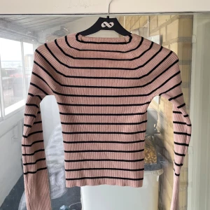 Brun randig ribbad tröja med v-ringning - Supersnygg brun ribbad tröja med svarta ränder och unik v-ringad hals.  Materialet är stretchigt och mjukt.