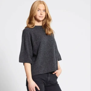 Mörkgrå stickad tröja  - Mörkgrå stickad kortärmad tröja från Lager 157 i storlek XS. Använd ett par gånger och är därför lite nopprig men annars bra skick, hör av dig ifall fler bilder önskas!