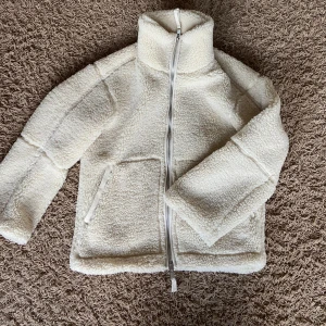 Vit teddyjacka från H&M XS - Mysig vit teddyjacka från H&M i storlek XS. Jackan har hög krage, två sidofickor och hel dragkedja framtill. Perfekt för kalla dagar. Jättebra skick och använd endast fåtal gånger!💗