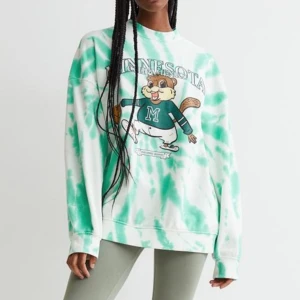 Minnesota Chipmunks tie-dye sweatshirt - Cool långärmad sweatshirt med grönt och vitt tie-dye mönster och stor print med en tecknad ekorre som spelar basket. Texten 'Minnesota Chipmunks' och 'Upper Midwest Champions' på framsidan.  Mjuk bomullskvalitet och normal passform, perfekt för chill dagar.  Den har tyvärr några fläckar, men det borde försvinna i tvätten. Printer är inte i sitt bästa skick (se bilderna).  Storlek XS. Från H&M. 