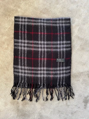 Burberry halsduk - Snygg och klassisk Burberry scarf i mjuk kashmir med fransar. En enkel detalj som lyfter vilken outfit som helst. | Mått: ca 168 × 30 cm | | Material: 100 % kashmir | | Mycket bra skick |