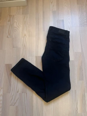 Mörkblåa jeans från Bison W30 L32 - Säljer ett par svart mörkblåa jeans från Bison i klassisk femficksmodell. Jeansen har smal passform och raka ben, med snygga detaljer som kontrastsömmar och en diskret logotyp på insidan. Perfekt för dig som gillar stilrena och enkla jeans. Köpta hos Wagner för 999kr, säljs för 449kr pga för små för mig.