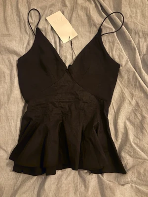 Svart topp från Zara - Skit snygg fest topp från Zara! Aldrig använd. Den är v ringad och är figurformad i midjan, perfekt nu till nyår. Strl S men skulle säga mer xs/s. Dm för fler bilder ❤️