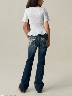 Blå bootcut jeans med broderade fickor - Slutsålda på Ginatricot! Snygga blåa jeans med bootcut-modell. Osäker på storlek men runt 150-160 (xs). Perfekta för dig som gillar en lite vidare passform nertill och coola detaljer. Använd runt 2-3 gånger , helt utan skador! Säljer för 300kr med frakt runt 40-60kr vad jag vet.  pris kan diskuteras. Köp sker endast genom Swish