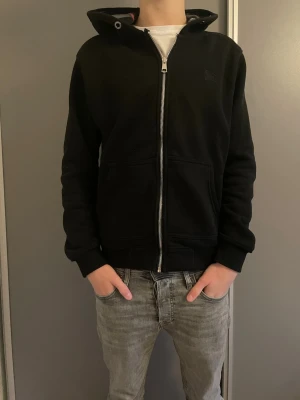 Burberry hoddie svart  - Säljer nu min svarta hoodie ifrån Burberry. Den är i storlek S och passar dig som är runt 165-175. Modellen på bilden är 173. Den är använd flitligt nårra få gånger, så det finns inga tecken på större användning. Tyvärr saknas snörena till hoodien. Är perfekt till dig som vill ha något varmt men ändå väldigt skönt! Hör av er vid frågor och funderingar. MvH VJresell