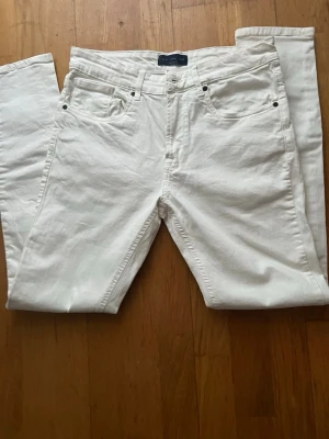 Vita jeansbyxor från Danmark  - Säljer ett par fräscha vita jeansbyxor från Zara med klassisk femficksdesign och silverfärgade nitar. Byxorna har rak passform och normal midja, tillverkade i mjuk bomull med lite stretch för extra komfort. Perfekt för dig som gillar stilrena och enkla jeans. Fått den som en present. Skriv gärna för mer bilder eller frågor