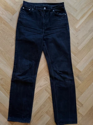 Svarta raka jeans från ARKET - Säljer ett par sot-svarta jeans från ARKET i rak modell. Jeansen är tillverkade i ekologisk bomull och har klassisk femficksdesign. Snygg, enkel look som passar till allt och är superlätta att styla.