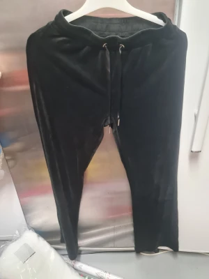 Svarta mjukisbyxor från Gina Tricot XS - Svarta mjukisbyxor från Gina Tricot i storlek XS. Byxorna har en mjuk och glansig sammetstextur, elastisk midja med snörning och avslappnad passform. Perfekta för chill dagar och har en stilren look med enkel design.