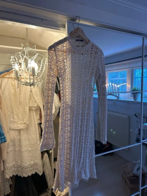 Vit långärmad virkad klänning - Säljer en vit långärmad klänning från NA-KD med virkad design och rund hals. 
