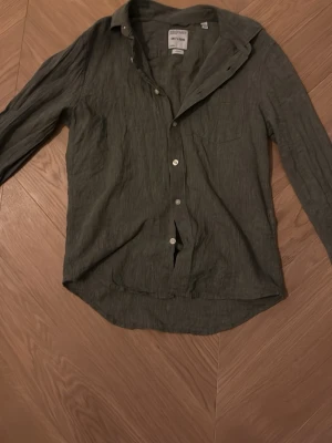 Grön linneskjorta från Only & Sons - Snygg grön skjorta från Only & Sons i mjukt linne. Skjortan har klassisk krage, lång ärm och knappar framtill. En bröstficka ger extra stilpoäng. Perfekt för dig som gillar chill och enkel stil.