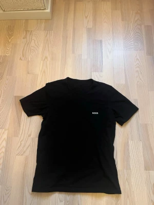 2 st Hugo Boss t shirts - En Svart t-shirt från BOSS i storlek M och en marinblå i samma storlek. Klassisk rund hals och korta ärmar. Diskret BOSS-logga på bröstet Tillverkad i mjuk bomull som känns skön mot huden. Perfekt för dig som gillar stilrena och enkla plagg med snygg passform. Båda 2 för 80 kr tillsammans.