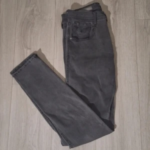 Raplay anbass hyperflex slim fit - Snygga grå jeans från Replay med klassisk femficksdesign och skinny passform. Jeansen har svarta detaljer vid fickorna och Replay-logga på både linning och myntficka. Tillverkade i stretchigt jeanstyg för en bekväm känsla.