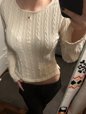 Vit stickad tröja från Nelly - Säljer en vit stickad tröja från Nelly med kabelstickat mönster. Tröjan har lång ärm, rund halsringning och lätt croppad passform. Perfekt till höst och vinter för en mysig och stilren look.