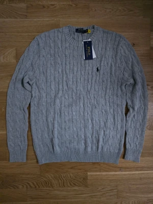 Grå kabelstickad tröja Polo Ralph Lauren  - En grå kabelstickad tröja från Ralph lauren i storlek M för ett jätte billigt pris.
