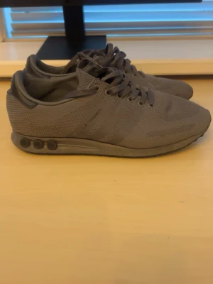 Adidas Ultraboost & adidas la trainer - Två par Adidas sneakers säljes! Ett par mörkgrå Adidas Ultraboost med stickad ovandel, vita Boost-sulor och klassiska tre ränder på sidan. Det andra paret är Adidas Trainer i helgrått med diskret mönster och snörning. Båda paren är riktigt sköna och passar perfekt till vardags eller träning. De blåa ultra boost är storlek 40. De gråa paret är storlek 39 och en tredjedel står det