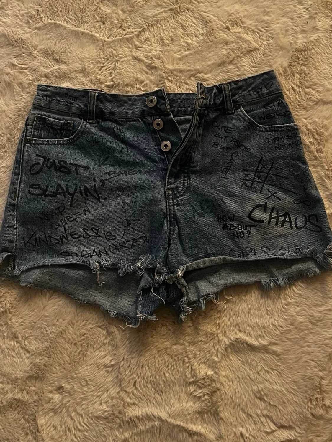 Blå jeansshorts med graffiti-tryck