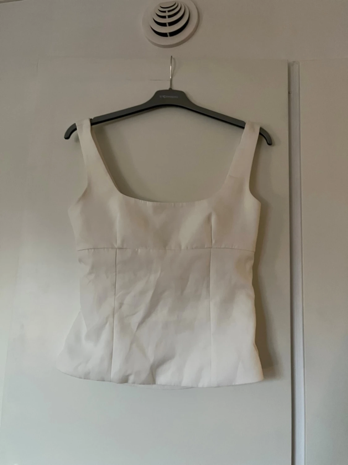 Vit linnetopp med rosett och öppen rygg