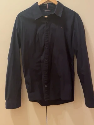 Mörkblå skjorta från Tommy Hilfiger - Klassisk mörkblå skjorta från Tommy Hilfiger. Passar bra till ett par jeans eller ett par chinos. Hör av er vid intresse !