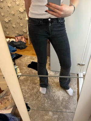 Gråa low waist bootcut jeans - Säljer ett par gråa bootcut jeans . Jeansen har klassisk femficksdesign, normal passform över låren och lätt utsvängda ben. Strchigt material och färgen är mörkgråsvart. Lagom långa för mig som är 167 