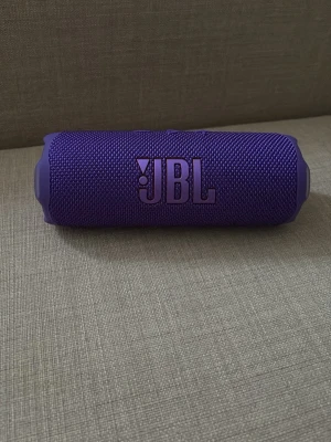 JBL Flip 7 - JBL Flip 7 bärbar Bluetooth-högtalare i lila. Vattentålig design, upp till 16 timmars batteritid och Bluetooth 5.4. Produkten ser ut att vara i nyskick med originalförpackning och tillbehör. Perfekt för musik på språng, både inomhus och utomhus. Jag har bara tagit ur den från lådan finns ej laddare 
