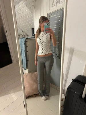 Grå mjukisbyxor från Gina Tricot - Supermysiga grå mjukisbyxor från Gina Tricot med bred ribbad midja. Byxorna har en rak passform och är perfekta för chill dagar. Materialet är mjukt och stretchigt för extra komfort.