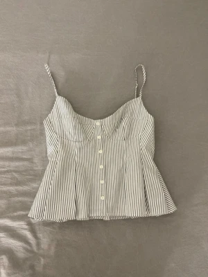 Randig topp  - Säljer denna snygga och populära toppen från Zara Toppen har tunna axelband, knappar framtill och en lätt utsvängd passform. Säljer då den inte har kommit till användning. Ny med prislapp 💗