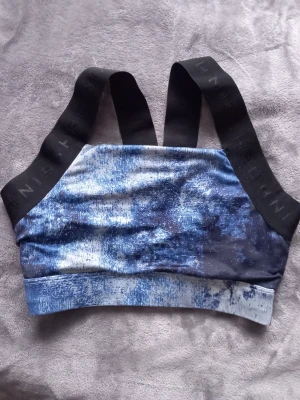 En blå och svart sport-bh från Röhnich - En blå och svart sport-bh från Röhnich i st S.(passar även till XS). Knappt andvänd som nyskick.