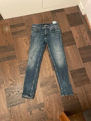 Replay blå jeans, tapered fit - Säljer ett par klassiska blå jeans från Replay med snyggt tvättad look och tapered fit. Jeansen har fem fickor, Replay-lapp bak i midjan och kontrastsömmar. Materialet är slitstarkt jeans-tyg i bomull. Perfekta till sneakers eller boots.