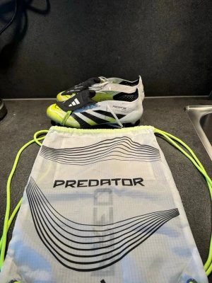 Adidas Predator fotbollsskor vit/svart/gul - Säljer ett par Adidas Predator fotbollskor elit andvända 3 gånger kommer med elit påsen några frågor eller funderingar bara att skriva. Ordinarie pris 2399kr