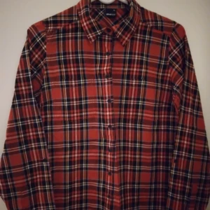 Röd rutig skjorta för kvinnor. Gina Tricot. Strlk: 34 / XS-SMALL. Bomull. Oanvänd och felfri. - Röd rutig skjorta för kvinnor. Från Gina Tricot. Strlk: 34 / XS-SMALL. Bomull. Oanvänd och felfri.