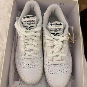 Äkta Reebok x Maison Margiela vita sneakers - Unika vita sneakers från Reebok i samarbete med Maison Margiela. Modellen har coola synliga sömmar, klassisk siluett och detaljer i både skinn och syntet. Skriva till mig för flera bilder, bevis, osv