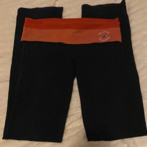 Svarta leggings från Hollister S - Svarta leggings från Hollister med bred röd midjeresår och logga framtill. Snygg och bekväm passform. Pris diskuteras!