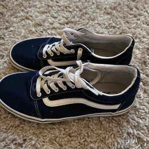 Marinblåa Vans Old Skool sneakers - Säljer ett par klassiska Vans Old Skool sneakers i marinblått med vit sula och vit sidestripe. 