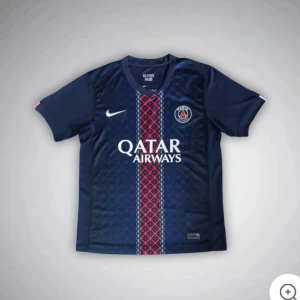 PSG matchtröja Nike marinblå - Snygg PSG fotbollströja från Nike i marinblått med rött och vitt geometriskt mönster längs mitten. Tröjan har korta ärmar, rund hals och PSG-logga på bröstet. Materialet är lätt och andas, perfekt för träning eller match.