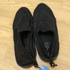 Svarta badskor från Bluefin, storlek 46 - Svarta badskor från Bluefin. Perfekta för stranden eller poolen.